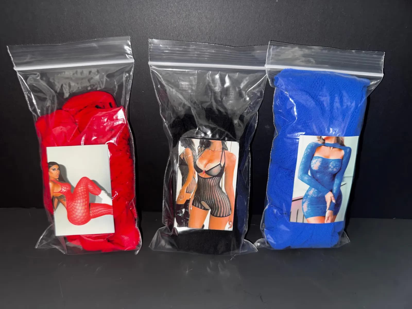 Three packaged dancer outfits in red, black and blue