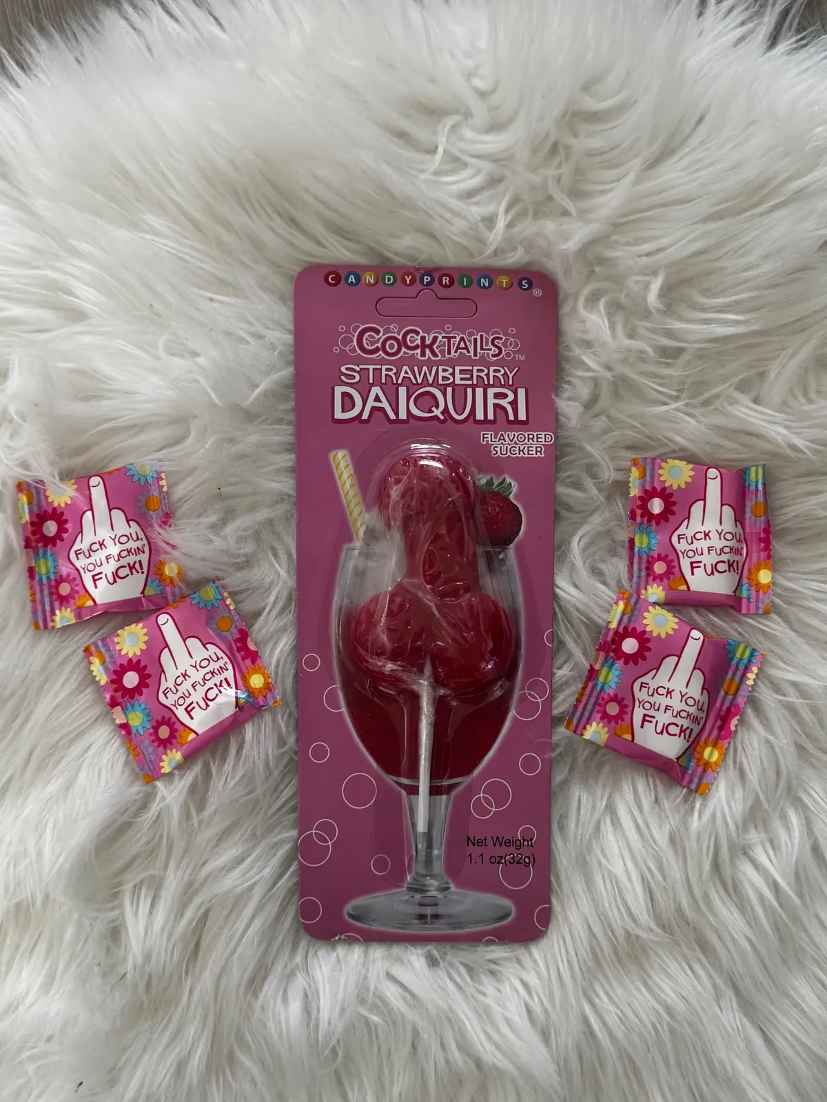 Strawberry daiquiri lollipop and novelty candy packs on white fur